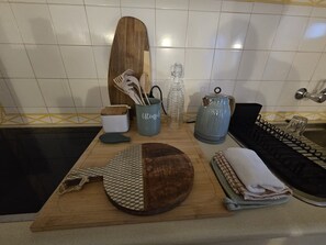 Eine Küchenarbeitsplatte mit Schneidebrett, Messerblock, Wasserkocher und Spüle.