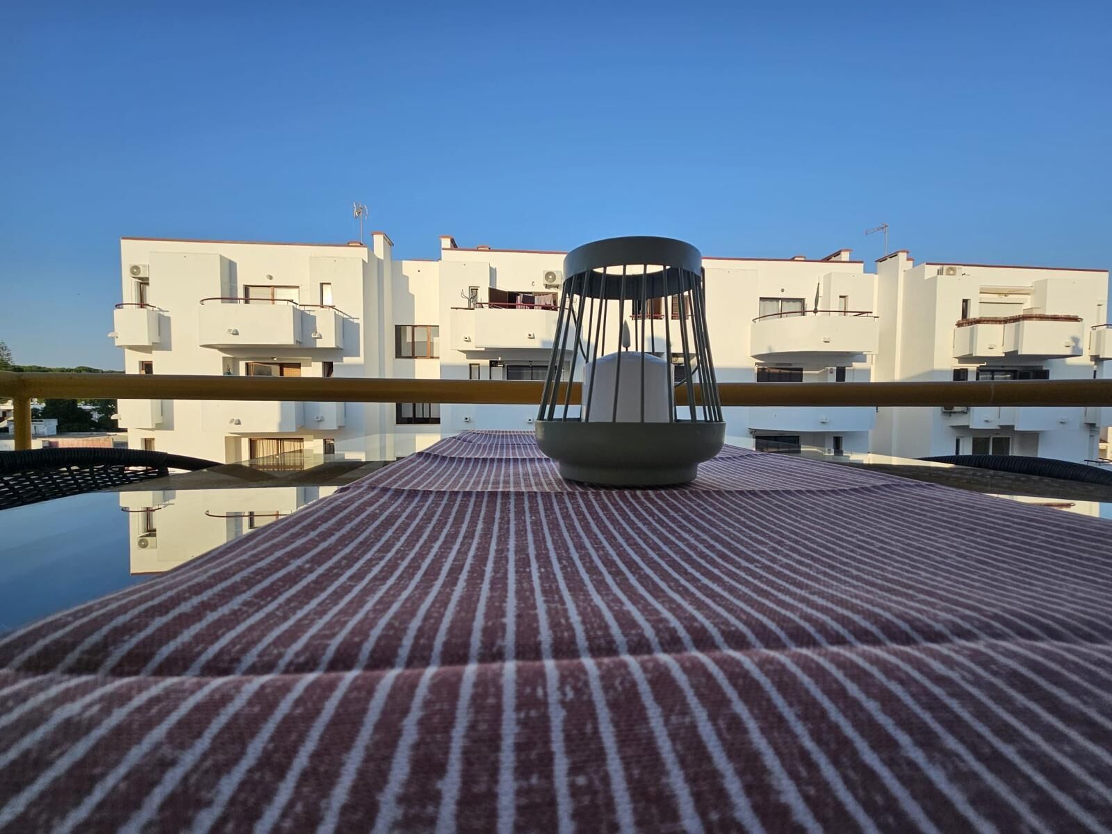 A modern building with balconies and a clear sky.