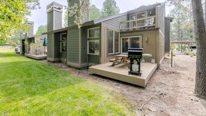 Ein modernes Mehrfamilienhaus mit Terrasse, Sitzgelegenheit im Freien und Grillplatz.