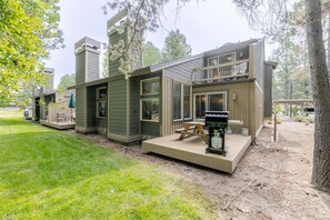 Una casa moderna de varios pisos con terraza, mobiliario exterior y zona de barbacoa.