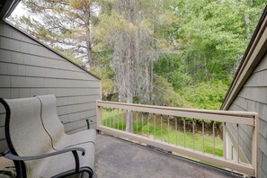 A balcony with a chair, a railing, and a view of trees. - 9 Quelah Condo- Community Pool, Community, BBQ & Fireplace (Bend)