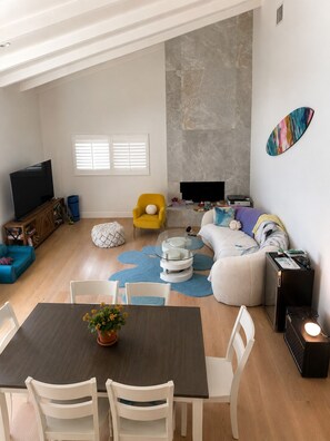 A modern living room with a dining area, a sofa set, a TV, and a fireplace. - Charming Modern House in Los Angeles, Walkable and Quiet (Los Angeles)