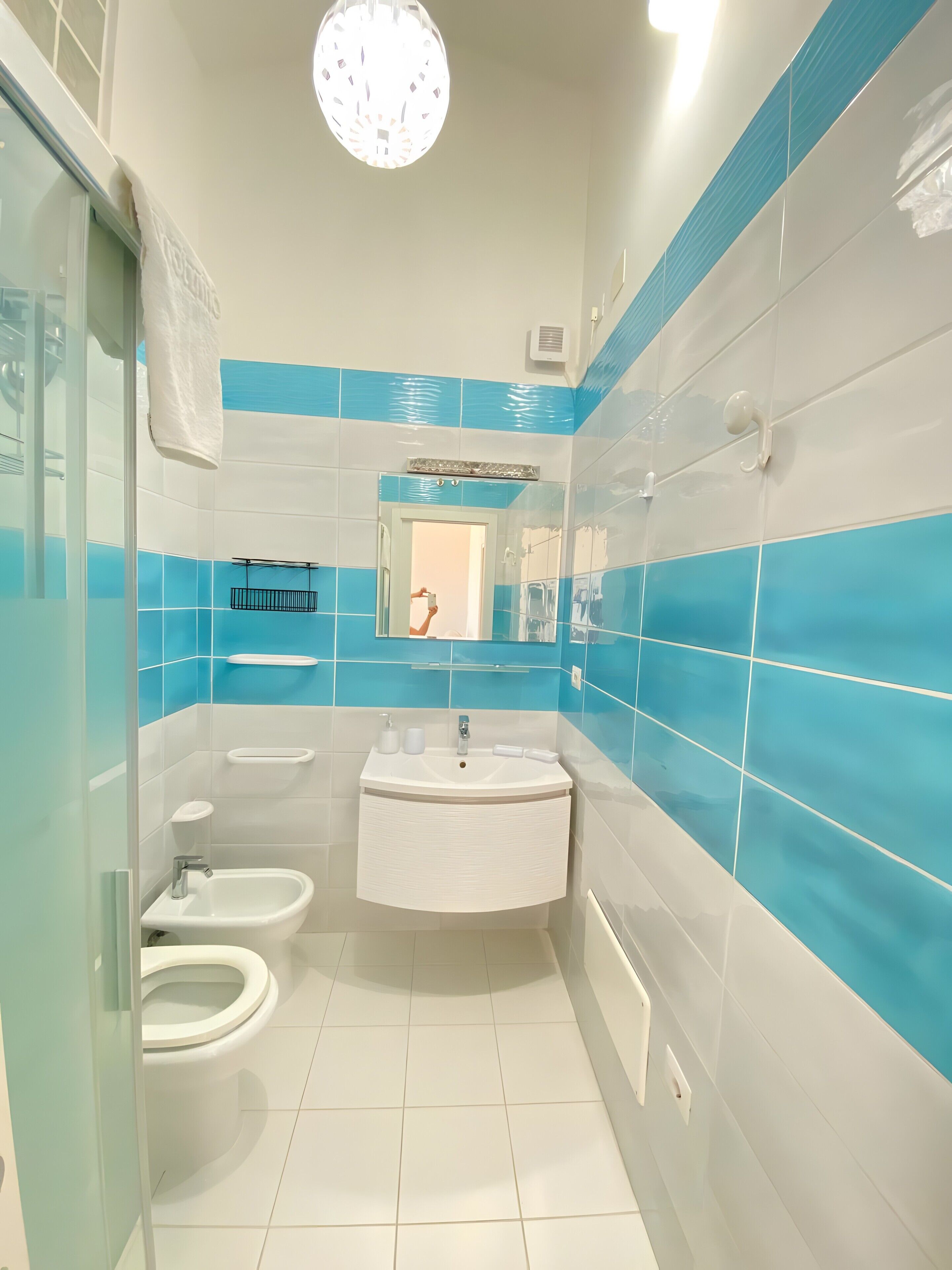 Ein Badezimmer mit Waschbecken, zwei Toiletten, einem Spiegel und einer Duschkabine.