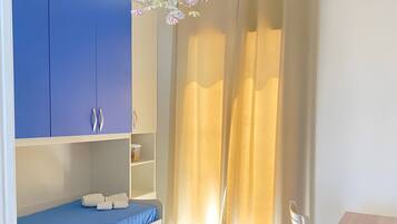 Ein Zimmer mit Etagenbett, einem Holztisch, einem weißen Stuhl und einer Kristallleuchtre.