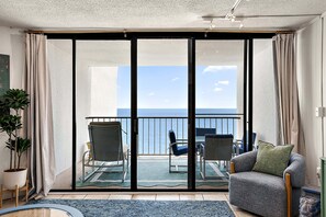 A balcony with a view of the sea, a sofa, and two chairs. - Oceanfront 1 Bed/1.5Bath-OutdoorPool-WiFi-Laundry (Ocean City)