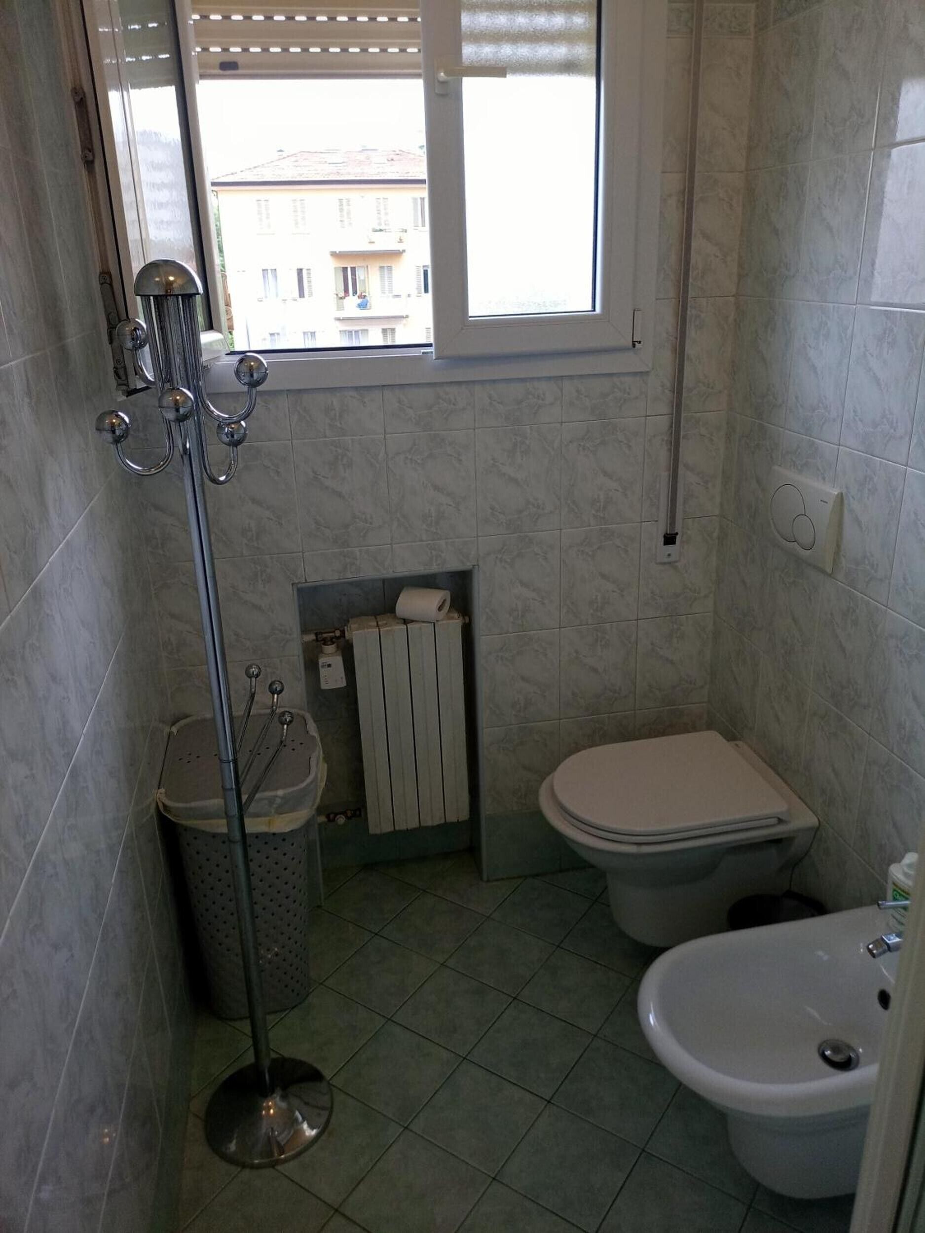 Ein kleines Badezimmer mit Toilette, Bidet und Fenster.
