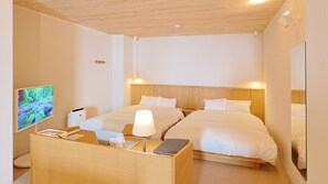 A hotel room with two beds, a desk with a lamp, a television, and a wooden ceiling. - jiros garden (Isinomaki)