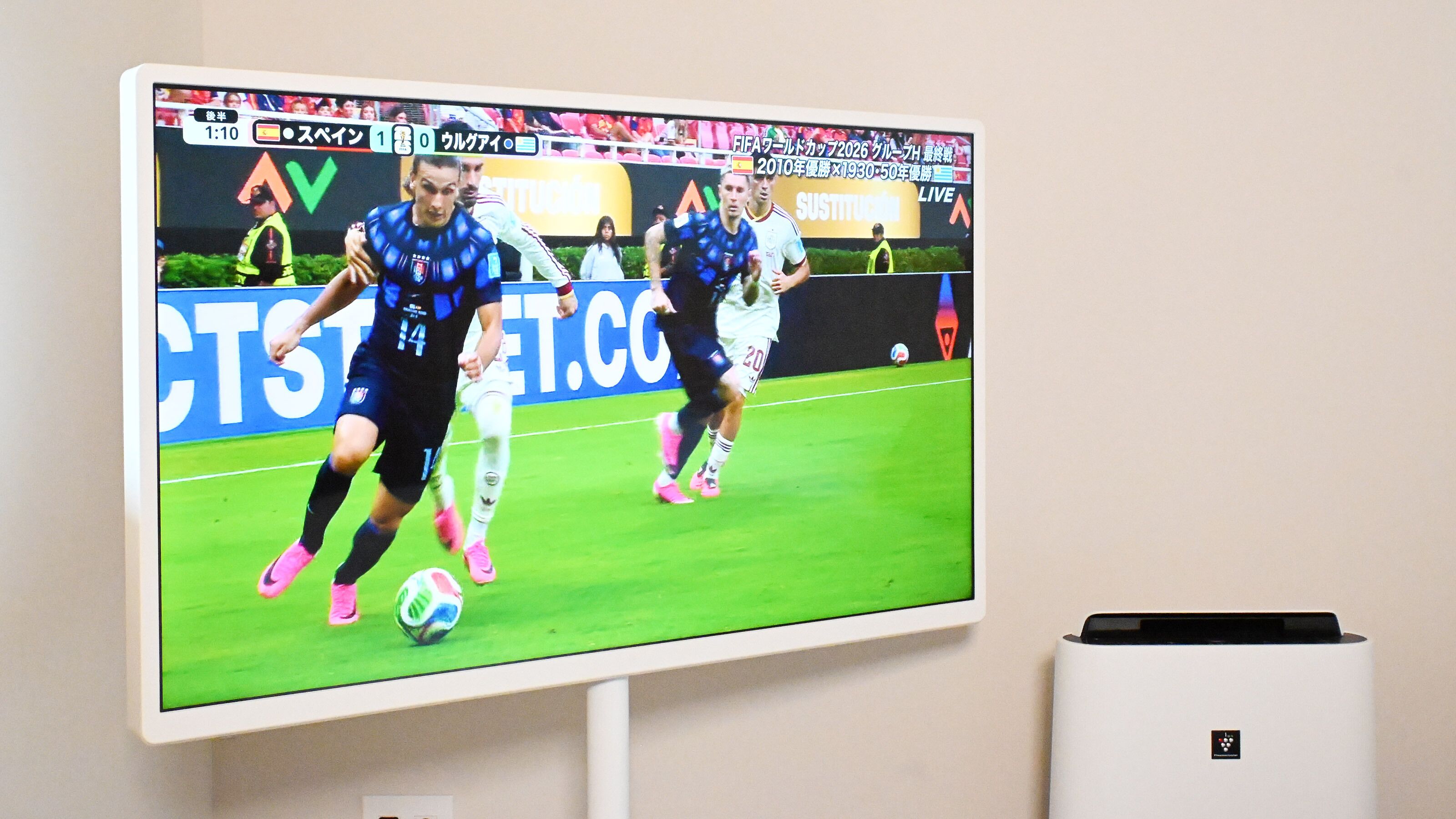 Ein Fernseher zeigt ein Fußballspiel mit aktiven Spielern.