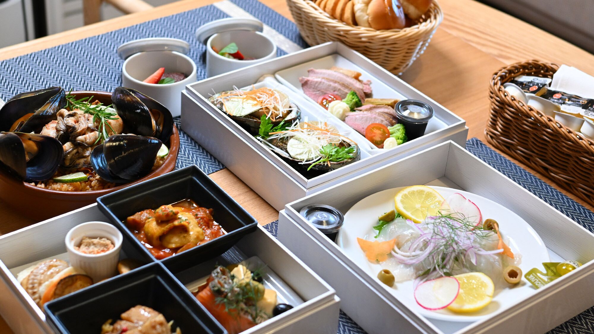 A variety of food dishes arranged on a table, including seafood, vegetables, and meats.
