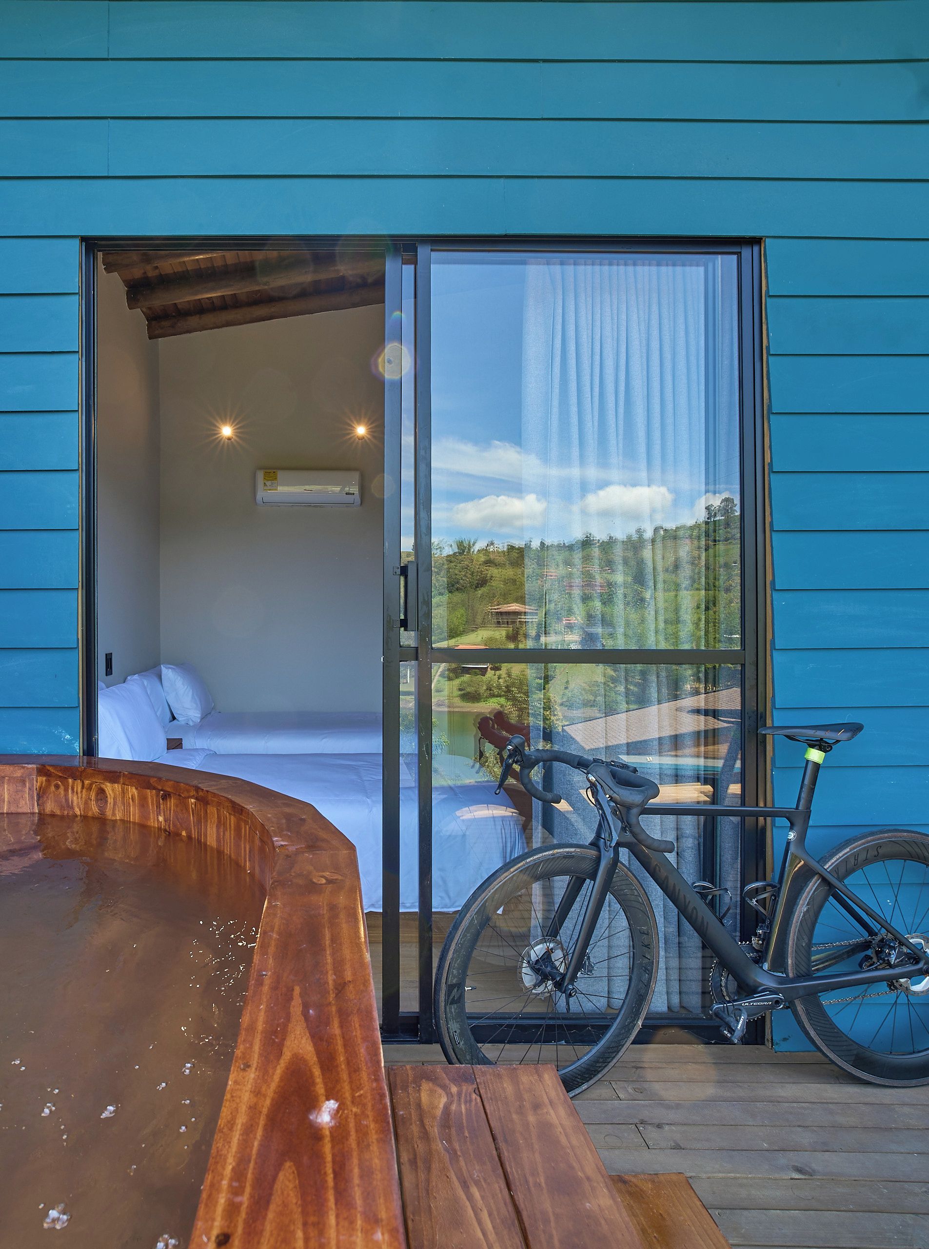 Quarto com cama, banheira de hidromassagem e bicicleta.