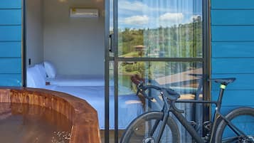 Quarto com cama, banheira de hidromassagem e bicicleta.