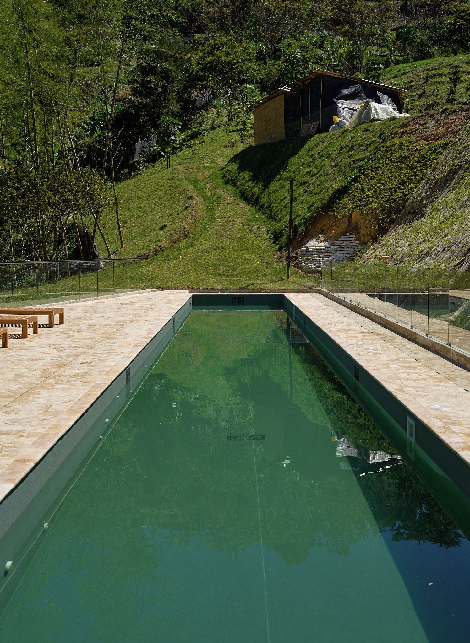Una piscina con vistas despejadas del paisaje circundante, incluyendo un edificio y árboles.