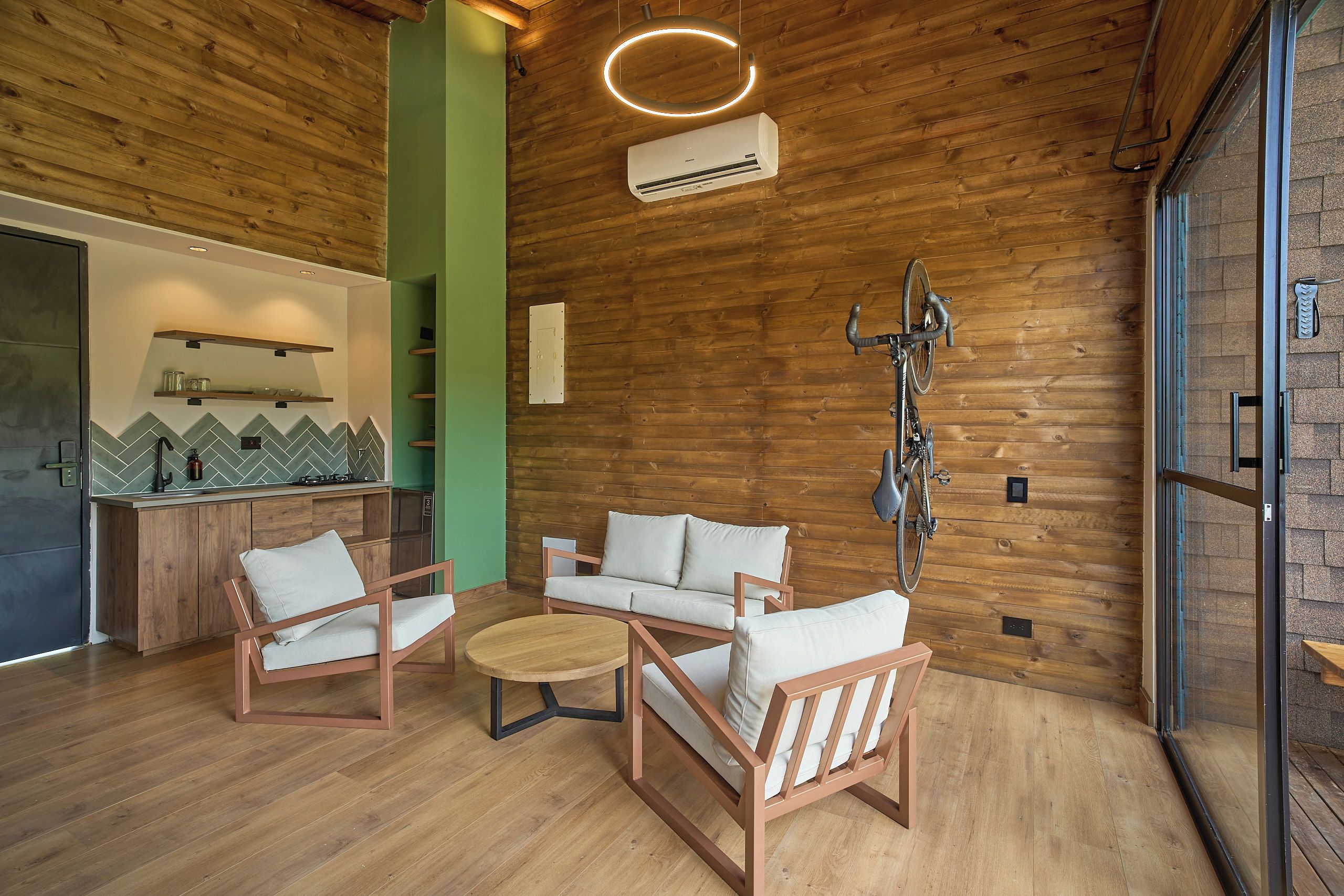 Un interior acogedor con paredes de madera, kitchenette y zona de estar.