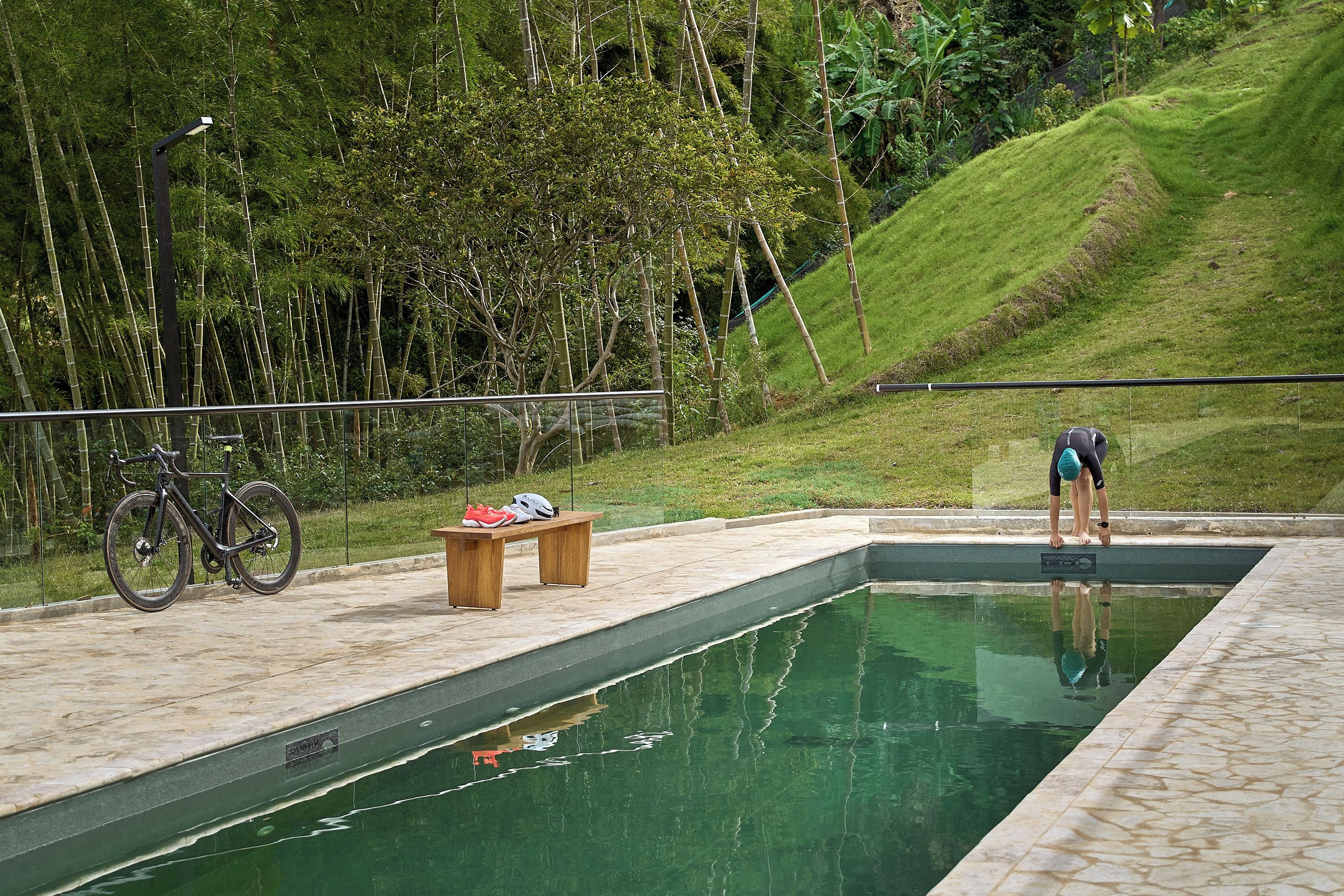 Una piscina con un banco de madera y una bicicleta.