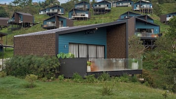 Una casa moderna con techo plano, ventanas grandes y un balcón.