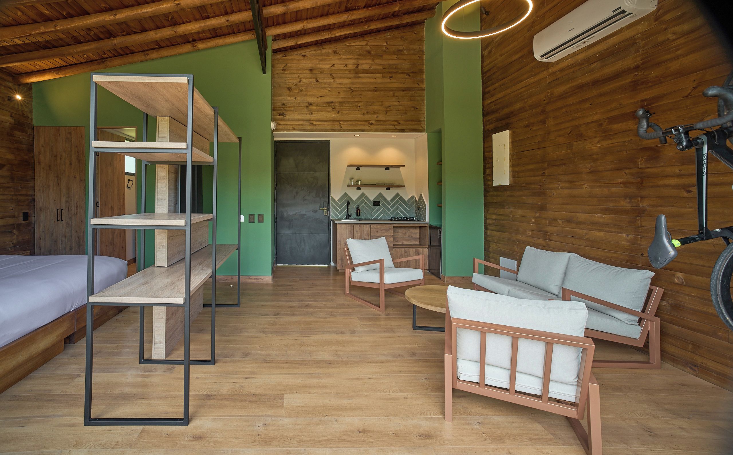 Una habitación pequeña con literas, sofá y una bicicleta.