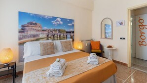 Et hotelværelse med en stor seng, udsigt til en historisk bygning, et spejl, et lille bord med en drink og en dør med teksten 'Borgo'.
