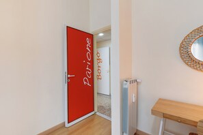 A hallway with a red door labeled 'Parione' and a white door labeled 'Borgo'. - Room 'Camera Familiare - Borgo' with Balcony, Wi-Fi and Air Conditioning (Rome)