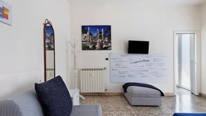 Ein modernes Wohnzimmer mit einer Couch, einem kleinen Tisch, einem Spiegel und einer Wand mit einem großen Poster.