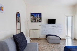 Ein modernes Wohnzimmer mit einer Couch, einem kleinen Tisch, einem Spiegel und einer Wand mit einem großen Poster.