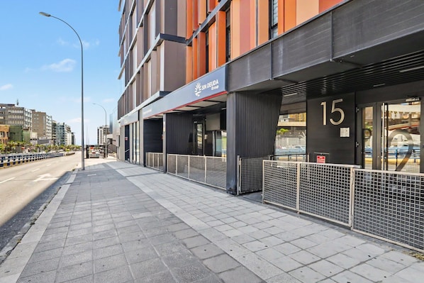 A modern building with a storefront labeled 'Sin Deuda Group' and a number '15' on the door.