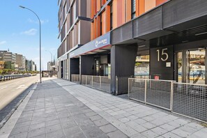 Een modern gebouw met een etalage waarop 'Sin Deuda Group' staat en het nummer '15' op de deur.