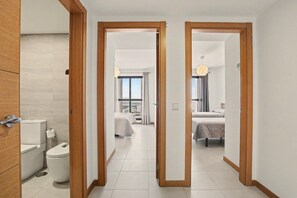 Een hotelkamer met een badkamer, een bed en uitzicht op de stad.