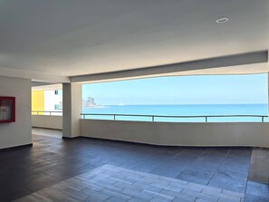 Quarto espaçoso com uma grande janela e vista para a costa.
