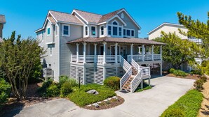 A two-story house with a porch, a staircase, and a well-maintained garden. - Mermaids Pearl: Sound Views, Village Beach Club and YMCA Access, Hot Tub (Nags Head)
