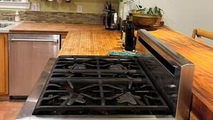Une cuisine équipée d’une cuisinière, de meubles en bois et d’une fenêtre.