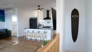 Una cucina moderna con isola centrale, sgabelli da bar e ventola a soffitto.