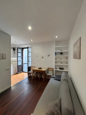 Eine moderne Wohnung mit Essbereich, einer Couch und einem Balkon.