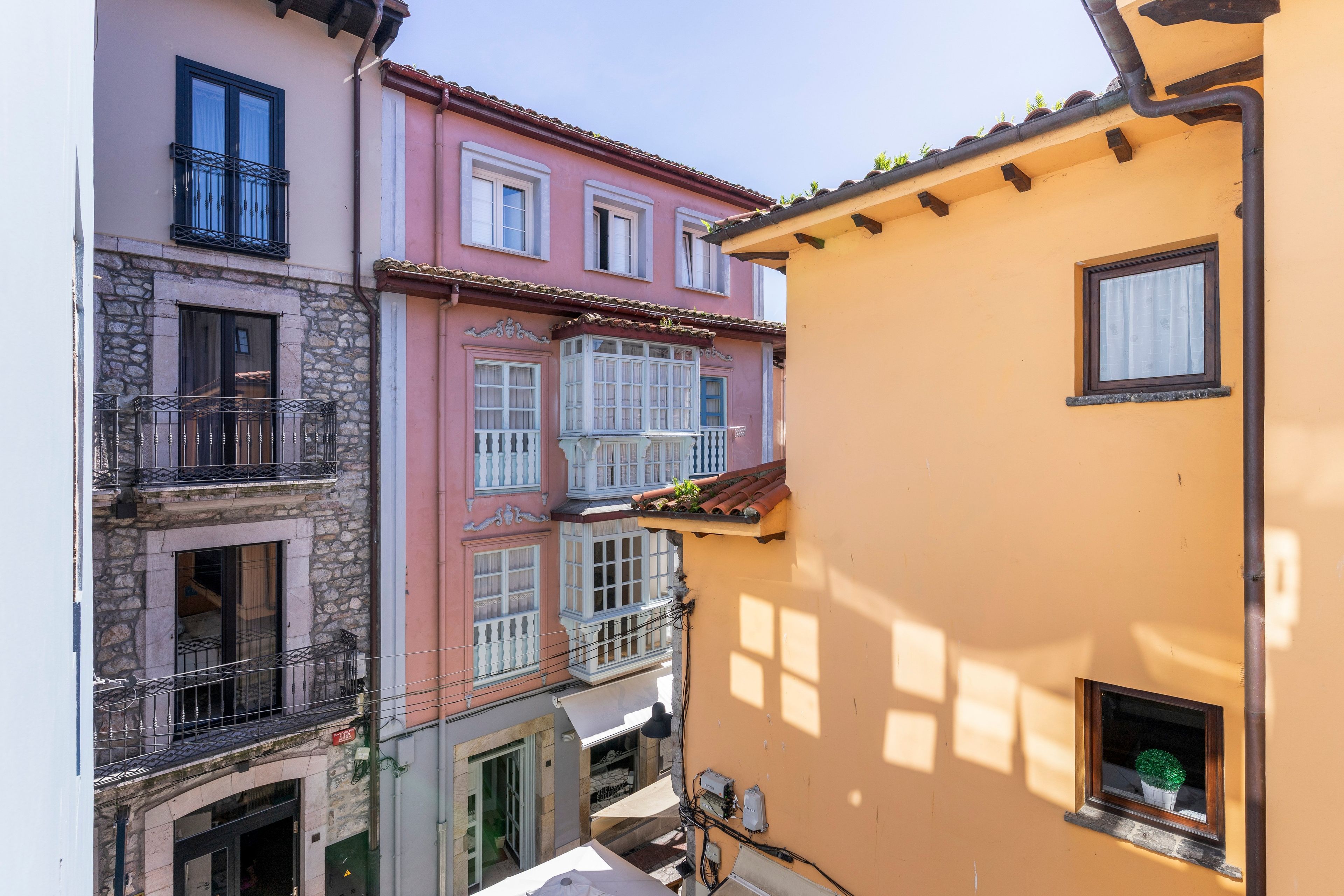 Una calle estrecha con edificios que tienen balcones y ventanas.