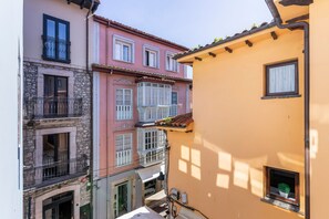 Una stretta via fiancheggiata da edifici con balconi e finestre.