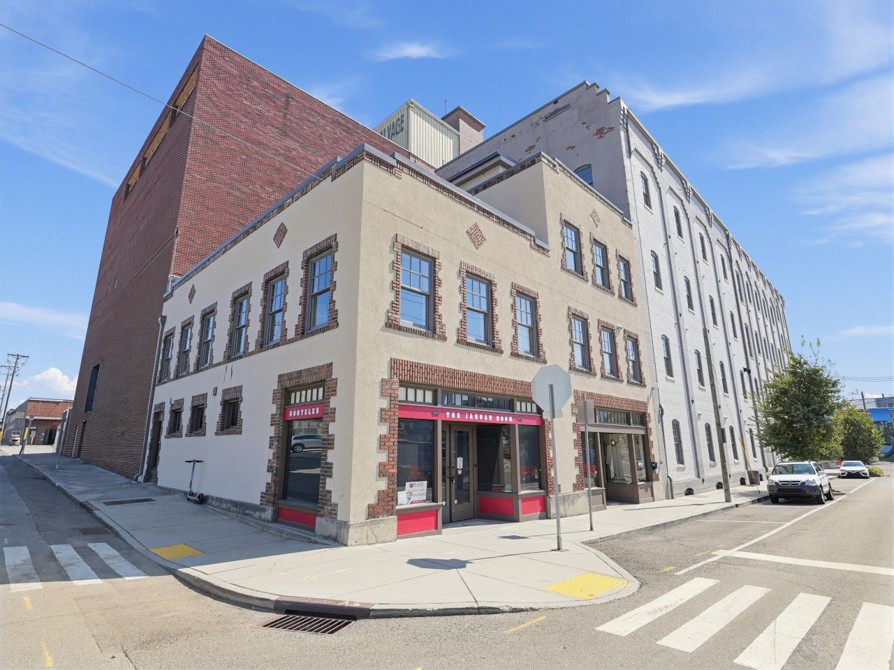 Un immeuble d’angle abritant un restaurant au rez-de-chaussée et des logements ou des bureaux aux étages supérieurs.