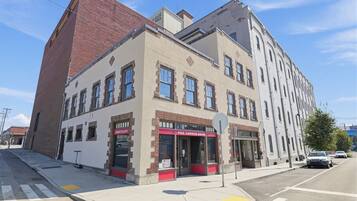 Un immeuble d’angle abritant un restaurant au rez-de-chaussée et des logements ou des bureaux aux étages supérieurs.