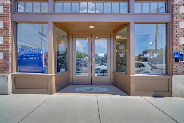 A building entrance with a glass door, a sign for 'Units for Sale,' and a visible street view.
