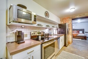 A modern kitchen with a coffee machine, stove, and dishwasher.