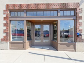 A building entrance with a double door, a visible number '222', and a sign reading 'WHITE LILY FLATS'.