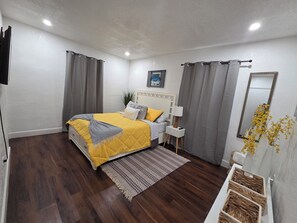 A bedroom with a bed, bedside table, lamp, curtains, and a mirror. - Delightful 2-bedroom house with AC in vibrant Miami (Miami)