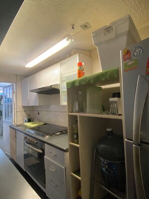 A kitchen with a stove, oven, refrigerator, and cabinets. - Your home away from home (Acapulco de Juárez)