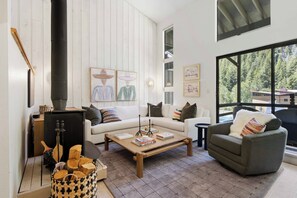 Ein gemütliches Wohnzimmer mit Kamin, Sofa, Sessel und Couchtisch.