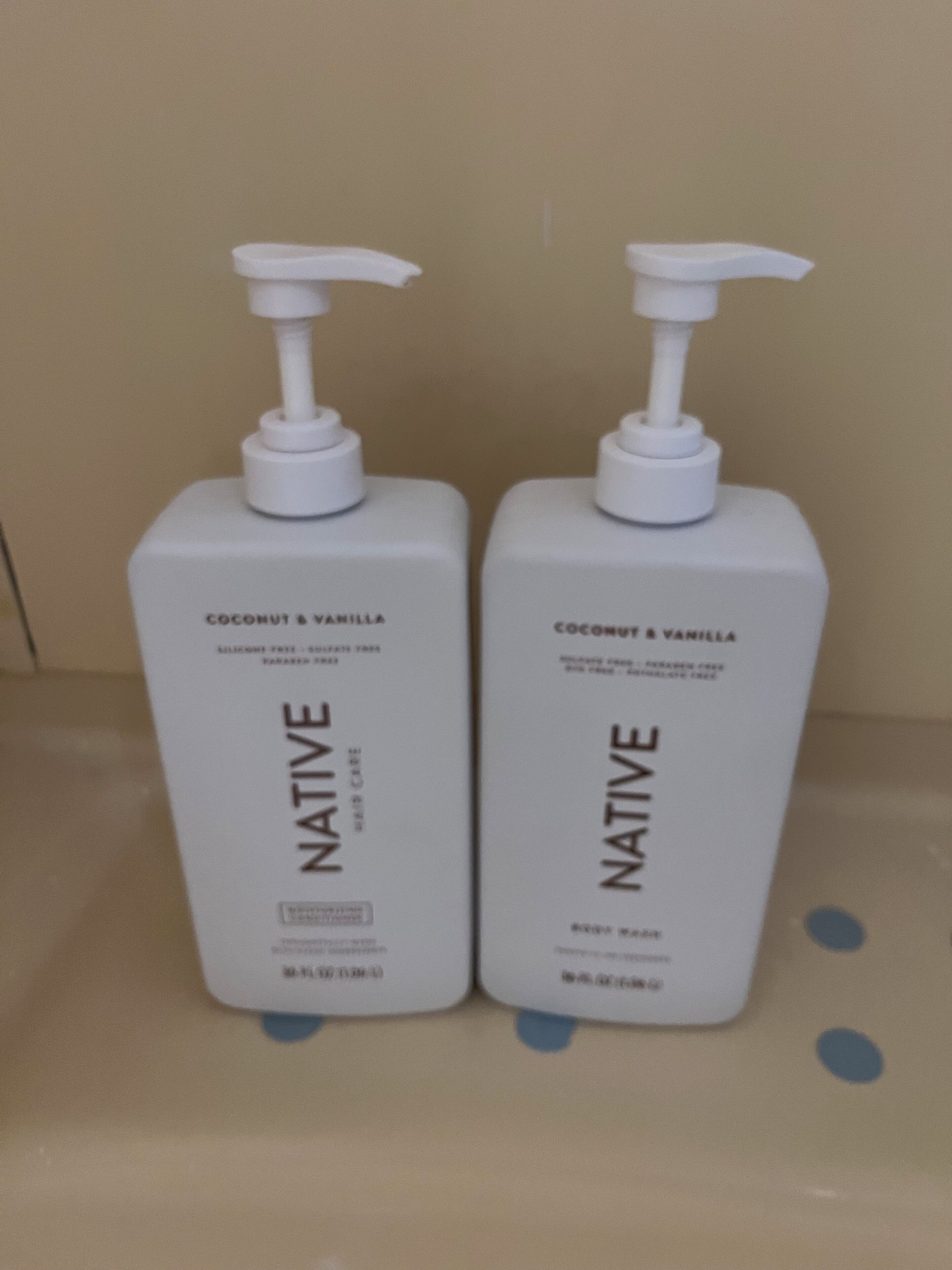 Two white bottles of Native body wash with coconut & vanilla scent.