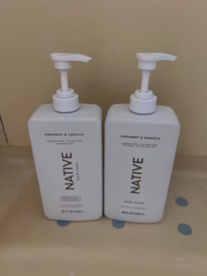 Dos botellas blancas de gel de baño corporal Native, con aroma a coco y vainilla.