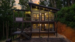 A multi-story cabin with a balcony, a staircase, and a view of the surrounding forest. - Laurel House TN. Serenity, security & privacy. (Sevierville)