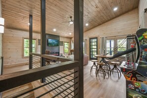 L’intérieur d’un chalet en bois comprend un coin repas, un bar et des jeux d’arcade.