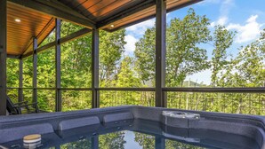 A hot tub with a wooden ceiling and large windows overlooking a forest. - Laurel House TN. Serenity, security & privacy. (Sevierville)