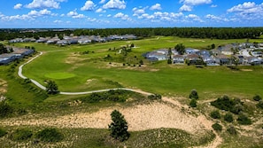 Ein Wohngebiet mit Häusern, einem Golfplatz und einer kurvenreichen Straße.