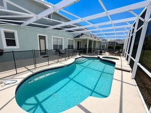 Un espace piscine doté d’une structure pour se protéger du soleil, de chaises longues et d’un patio couvert.