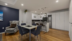 A modern kitchen with a central island, stainless steel appliances, and pendant lighting. - Central Peaks Retreat - walk to CBD (Queenstown)
